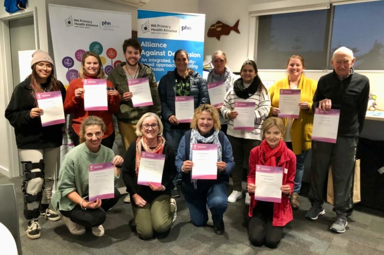 A group of 12 people smiling and holding the certificates after completing 2 days of YMHFA training
